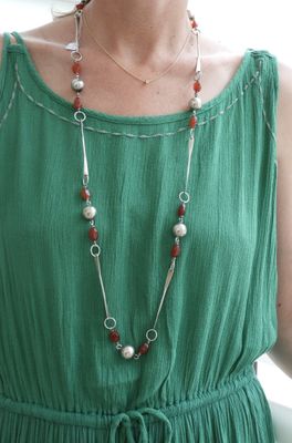 une femme vêtue d'une robe verte et portant un collier de perles