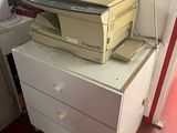 a stack of printers sitting on top of a white dresser