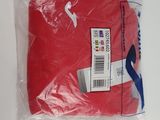 a red t - shirt wrapped in plastic on a table