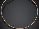 un collier en or avec un pendentif en forme de cœur serti d'un diamant