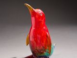 a red bird that is sitting on a white surface