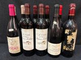 Plusieurs bouteilles de vin sont alignées sur une surface noire