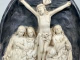 a statue of jesus on a crucif with people around it