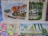 many cards that are on a table with a picture of a house in the background