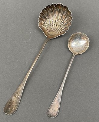 two spoons and a spoon rest on a gray surface