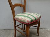 une chaise en bois dont l'assise et le dossier sont rayés