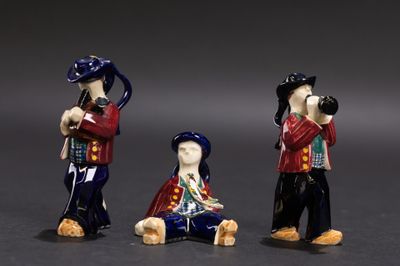 trois figurines représentant un homme avec un appareil photo et une femme avec un chien