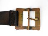 a brown belt with a metal buckle on a white surface