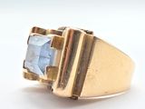 an image of a close up of a gold ring with a blue stone