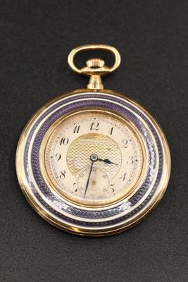 an image of a gold pocket watch on a black surface