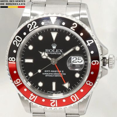 une montre Rolex avec une lunette rouge et noire