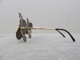 gold and black sunglasses on a white table with a white background