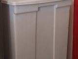 une poubelle blanche posée dans un coin de la cuisine