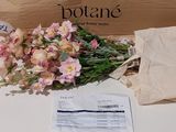 un bouquet de fleurs posé sur une table à côté d'un paquet