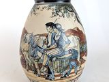 un vase sur lequel figure l'image d'un homme dans une calèche