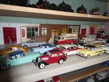 Des petites voitures sont alignées sur une étagère dans un magasin de jouets