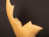 a wooden sculpture of a bird sitting on top of a wooden table