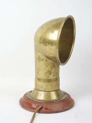 an antique brass pipe on a wooden base on a white background