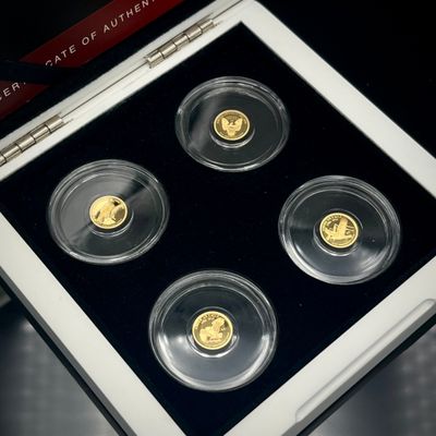 Quatre pièces d'or se trouvent dans une vitrine posée sur une table