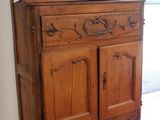 a wooden cabinet in a room with a door open