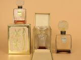 three bottles of perfume sitting next to each other on top of a table
