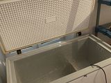 a white chest freezer sitting on the floor next to a ladder