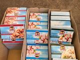 Plusieurs boîtes de nourriture pour bébé sont posées dans un carton posé par terre