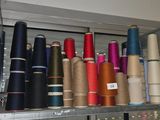 many spools of thread on a shelf in a room