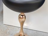 a black bowl sitting on top of a gold pedestal