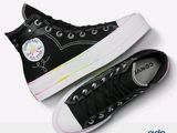 black converse sneakers with rainbow soles are on a white surface