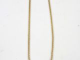 a gold chain necklace with three small white stones on it