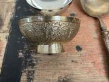 a lot of silver spoons and a bowl on a table