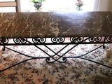 a table with a marble top on a rug in front of a window