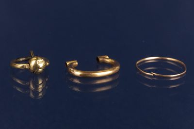 trois anneaux dorés sur une surface noire avec des reflets