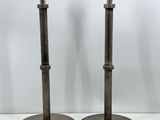 une paire de lampes de table en métal posées sur une surface blanche