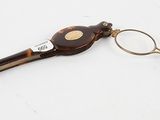 pair of eyeglasses and a pair of scissors on a white surface