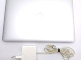 a white apple laptop with a charger attached to it
