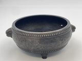 a close up of a metal bowl on a white surface