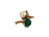 un gros plan d'une bague ornée d'une perle et d'une pierre verte