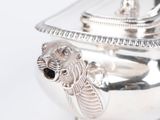 a silver bowl with a lid on a white surface