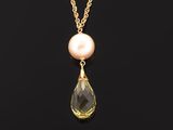 a gold necklace with a pink pearl and a gold chain