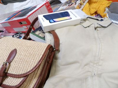 a purse and a cell phone sitting on a pile of luggage