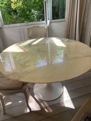 une table et des chaises en marbre dans une pièce