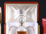 three perfume bottles in a red box on a black surface