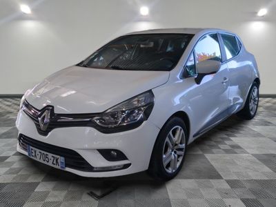 la voiture blanche est garée sur un sol en damier dans le garage