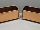 deux récipients métalliques posés sur une table blanche