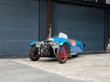 a blue and red car parked in front of a garage