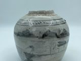 a black and white vase sitting on a white surface