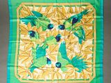 green and yellow parrots and leaves on a green and yellow square scarf