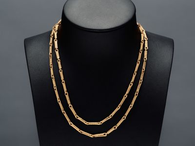 un collier à chaîne en or sur un mannequin, sur fond noir